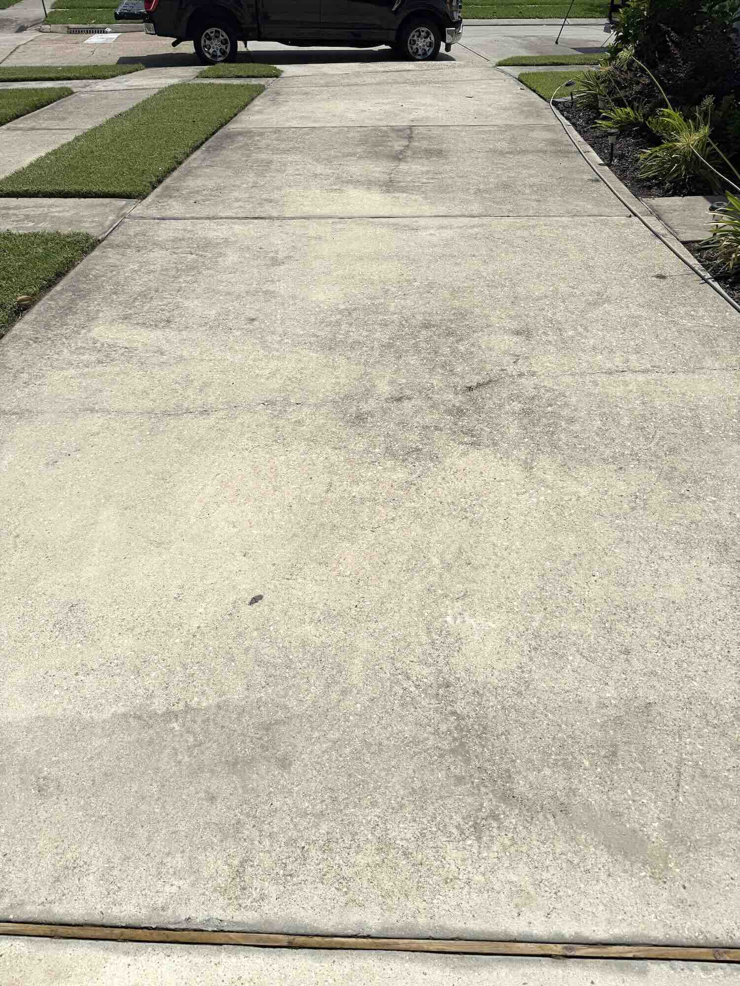 Dirty concrete driveway with heavy surface grime and discoloration before professional pressure washing in Metairie, Louisiana.