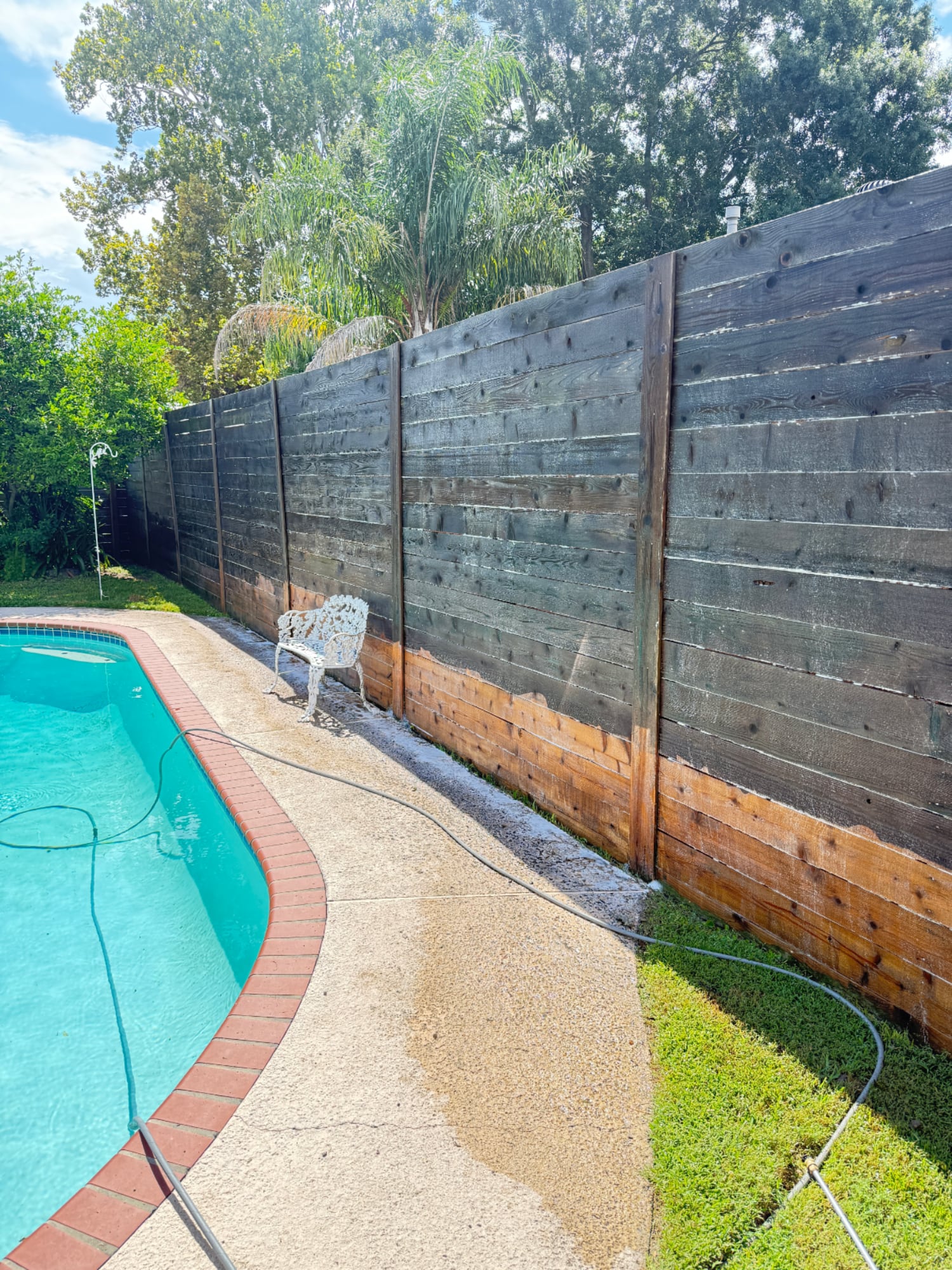 Weathered wooden privacy fence with dark mildew stains before professional pressure washing in New Orleans, Louisiana.