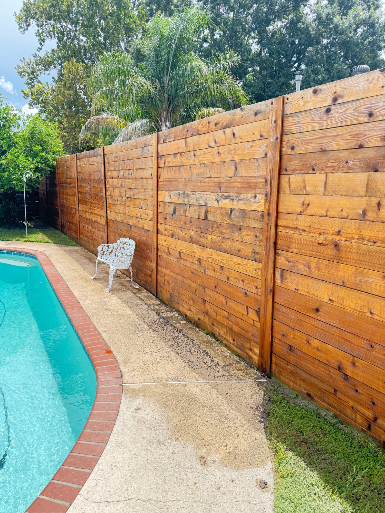 Restored wooden privacy fence with rich, natural color after expert pressure washing by Love Bug Pressure Washing in New Orleans, LA.