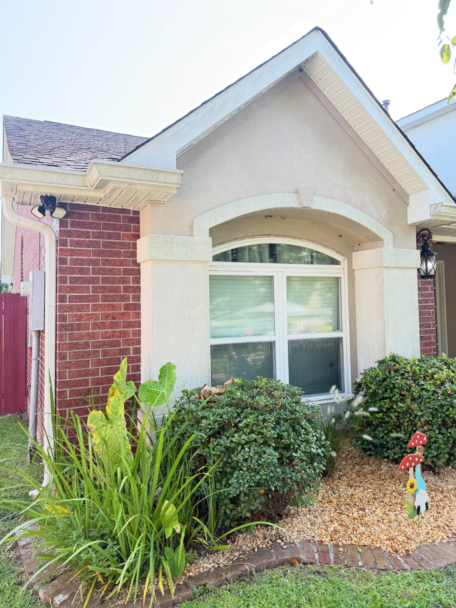 Stucco house exterior with dirt and mildew buildup around window before professional soft washing. Metairie, Kenner, Louisiana.