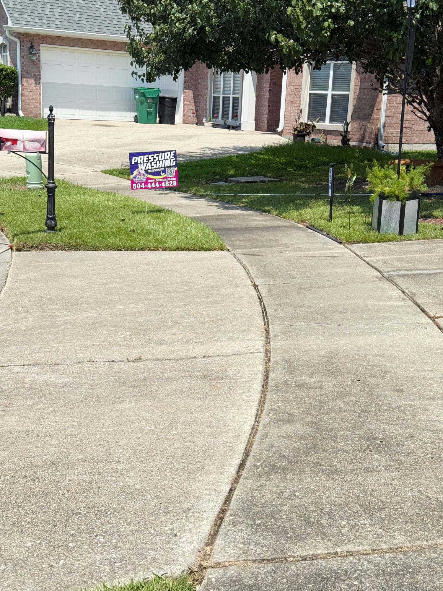 Stained residential sidewalk with grime and dark streaks before pressure washing in New Orleans, LA.