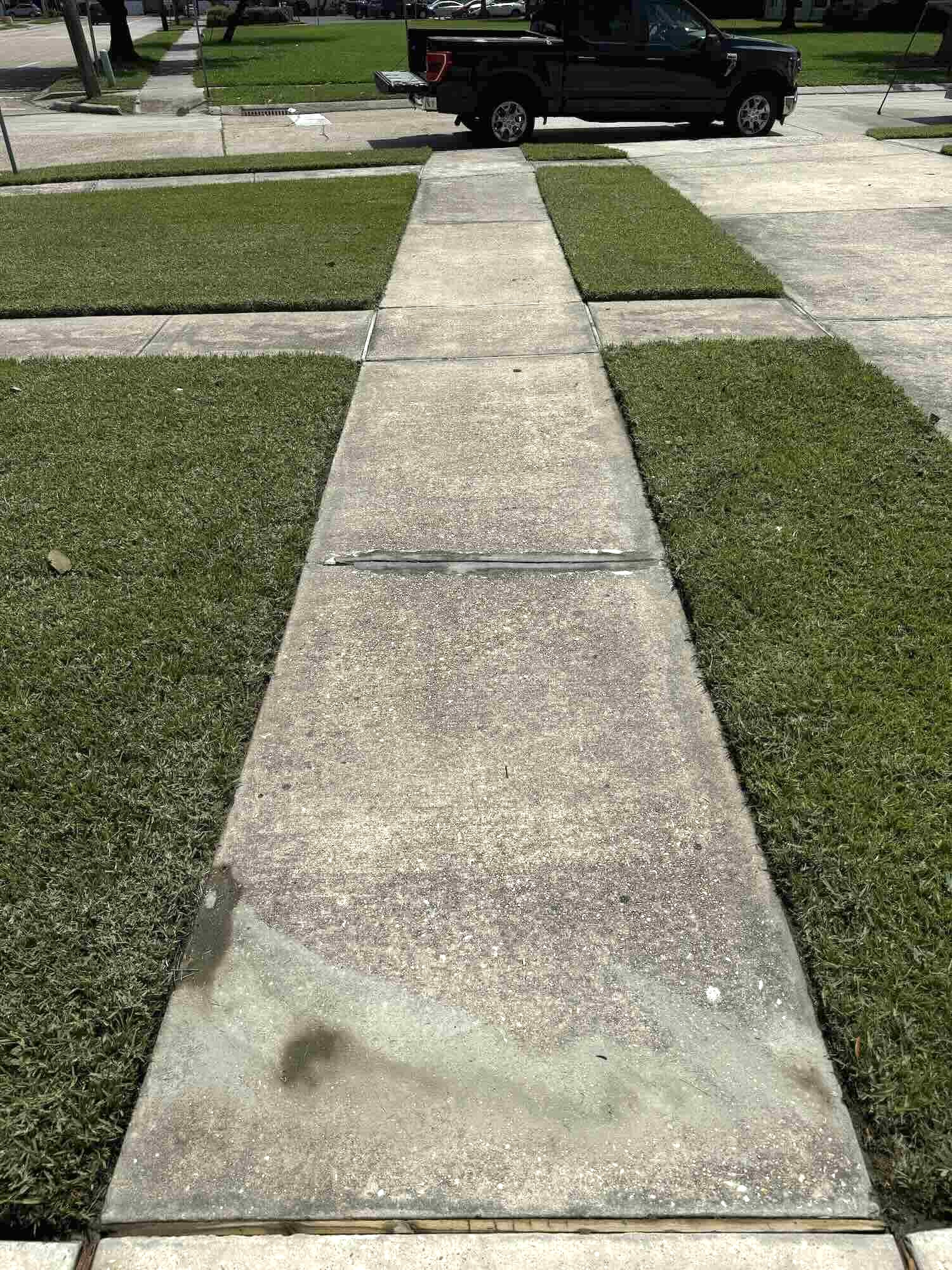 Grimy and stained sidewalk showing mold and dirt buildup before pressure washing in New Orleans, Louisiana.