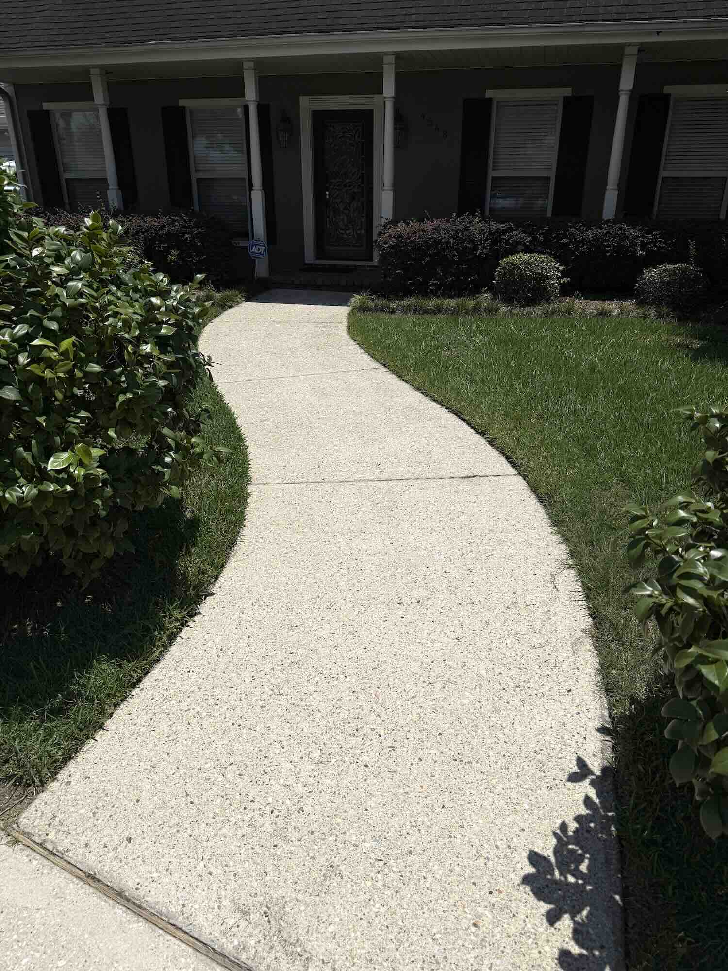 Bright and clean residential walkway after soft pressure washing in Metairie by Love Bug Pressure Washing.